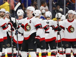 Senators captain Brady Tkachuk celebrates with teammates after scoring the overtime winning goal against the Islanders on March 16, 2024.