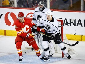 Calgary Flames forward Kevin Rooney and Los Angeles Kings defenceman Andreas Englund jostle for position as goalie David Rittich looks on at the Scotiabank Saddledome in Calgary on Saturday, March 30, 2024.