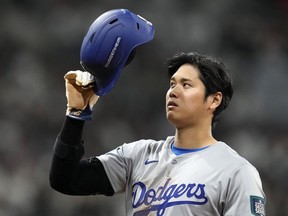 Los Angeles Dodgers designated hitter Shohei Ohtani takes his helmet off after hitting an RBI single during the eighth inning of an opening day baseball game against the San Diego Padres at the Gocheok Sky Dome in Seoul, South Korea Wednesday, March 20, 2024, in Seoul, South Korea.