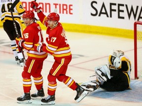Calgary Flames forward Yegor Sharangovich (17) celebrates a goal against Pittsburgh Penguins netminder Tristan Jarry with Dryden Hunt at the Scotiabank Saddledome in Calgary on Saturday, March 2, 2024.