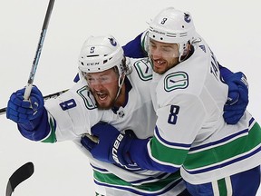 J.T. Miller and Chris Tanev celebrate eliminating the Wild in overtime of the 2022 playoff qualification round in the Edmonton bubble.