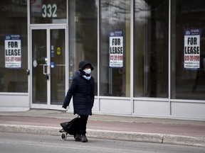 A person walks past an empty storefront in Ottawa on April 10, 2020.