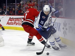 Winnipeg Jets' Rasmus Kupari (15) controls the puck after taking it from Carolina Hurricanes' Dmitry Orlov (7) during the first period of an NHL hockey game in Raleigh, N.C., Saturday, March 2, 2024.