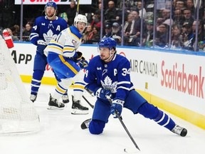 Toronto Maple Leafs forward Auston Matthews (34) controls the puck as he stumbles against the Buffalo Sabres during first period NHL hockey action in Toronto on Wednesday, March 6, 2024.