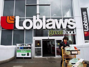 Customer pushing cart leaving a Loblaws grocery store.