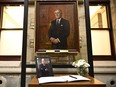 A photograph and book of condolences for Members of Parliament to sign are seen in front of the official portrait of former prime minister Brian Mulroney, in the antechamber to the House of Commons on Parliament Hill as Canadians mourn his death on Thursday at the age of 84, in Ottawa, Friday, March 1, 2024.