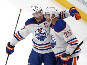Edmonton Oilers' Darnell Nurse (25) celebrates with Connor McDavid after scoring the first of two third period goals in an NHL hockey game against the Pittsburgh Penguins in Pittsburgh on March 10, 2024. The Oilers won 4-0.
