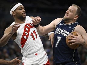 Orlando Magic guard Joe Ingles is fouled by Toronto Raptors forward Bruce Brown while driving to the basket during the first half of an NBA basketball game, Sunday, March 17, 2024, in Orlando, Fla.