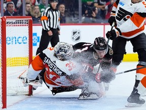 The Ottawa Senators' Ridly Greig collides with Philadelphia Flyers goalie Felix Sandstrom during the first period on Saturday, March 2, 2024, in Philadelphia.