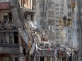 Rescuers clear debris from a multi-story building heavily damaged following a drone strike, in Odesa on March 3, 2024.