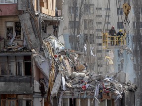 Rescuers clear debris from a multi-story building heavily damaged following a drone strike, in Odesa on March 3, 2024.