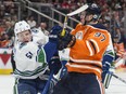 Connor McDavid of the Edmonton Oilers, collides with Troy Stecher of the Vancouver Canucks at Rogers Place in Edmonton on April 7, 2018. Photo by Shaughn Butts / Postmedia