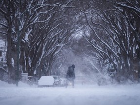 A person bundled up for the cold weather walks through blowing snow in Regina, on Sunday, March 3, 2024.