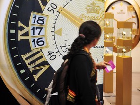 A visitor walks past a watch advertisement during the 30th Hong Kong Watch and Clock Fair on September 7, 2011.