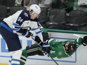 Winnipeg Jets defenceman Logan Stanley lays a hit on Dallas Stars' Logan Stankoven during the first period of an NHL game in Dallas on April 11, 2024.