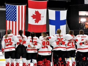 Canadian players watch as O Canada is played and the flags of the medal-winning nations are raised at the 2024 IIHF world women's hockey championship on April 14, 2024 in Utica, N.Y.