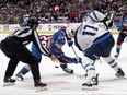 Winnipeg Jets captain Adam Lowry (right) contests a faceoff against Nathan MacKinnon of the Colorado Avalanche during the second period of Game Four of the first-round playoff series between the team on April 28, 2024 at Ball Arena in Denver.