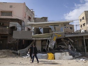 Palestinians inspect the damaged buildings in the West Bank refugee camp of Nur Shams, Tulkarem, Sunday, April 21, 2024. The Palestinian Red Crescent rescue service meanwhile said it has recovered more than a dozen of bodies from an Israeli raid in the Nur Shams urban refugee camp in the West Bank that began late Thursday. Those killed include three militants from the Islamic Jihad group and a 15-year-old boy.