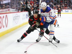 Ottawa Senators' Tim Stutzle battles for the puck with Brett Kulak of the Edmonton Oilers.