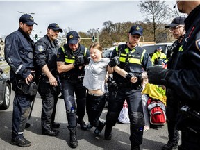 Swedish climate activist Greta Thunberg is arrested during a climate march against fossil subsidies near the highway A12 in the Hague, on April 6, 2024. Dozens of police officers, some on horseback, blocked protesters from reaching the A12 arterial highway into the Dutch seaside city, the scene of previous actions organised by the Extinction Rebellion (XR) group.