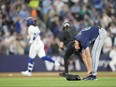 George Kirby of the Seattle Mariners adjusts his shoes as Bo Bichette of the Toronto Blue Jays rounds third after hitting a home run in the third inning at the Rogers Centre on Tuesday, April 9, 2024, in Toronto.