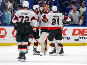 Anton Forsberg #31 of the Ottawa Senators is congratulated by Bokondji Imama #20 and Mathieu Joseph #21 after the shootout win against the Tampa Bay Lightning at the Amalie Arena on Thursday in in Tampa.