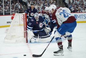 WINNIPEG, CANADA - APRIL 21: Connor Hellebuyck #37 of Winnipeg Jets defends his net against Ross Colton #20 of the Colorado Avalanche in Game One of the First Round of the 2024 Stanley Cup Playoffs at Canada Life Centre on April 21, 2024, in Winnipeg, Canada. (Photo by David Lipnowski/Getty Images)