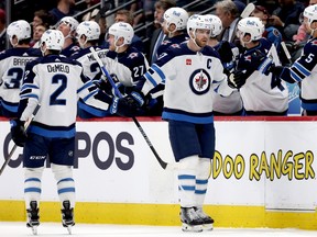 DENVER, COLORADO - APRIL 13: Adam Lowry #1 of the Winnipeg Jets celebrates with his teammates after scoring against the Colorado Avalanche in the second period at Ball Arena on April 13, 2024 in Denver, Colorado. (Photo by Matthew Stockman/Getty Images)