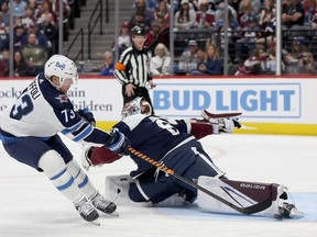 Goalie Justus Annunen #60 of the Colorado Avalanche saves a shot on goal by Tyler Toffoli of the Winnipeg Jets earlier this season.