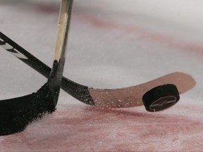 Sticks and the puck photogarphed during a faceoff