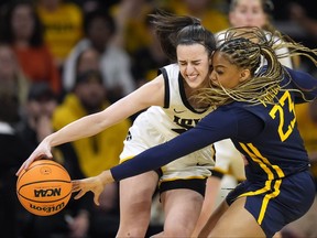 West Virginia guard Lauren Fields (23) tries to steal the ball from Iowa guard Caitlin Clark during March Madness play.