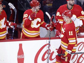 Calgary Flames' Mikael Backlund (11) celebrates his second goal against the Montreal Canadiens with teammate Jonathan Huberdeau (10) during second-period NHL action in Calgary on Saturday, March 16, 2024.