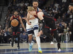 Toronto Raptors guard Gradey Dick, right, is fouled by Minnesota Timberwolves forward Kyle Anderson during the first half of an NBA basketball game on Wednesday in Minneapolis.