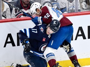 Colorado Avalanche's Caleb Jones (82) ties up Winnipeg Jets' Adam Lowry (17) during the first period in Game 2 of their NHL hockey Stanley Cup first-round playoff series in Winnipeg, Tuesday.