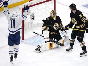 Toronto Maple Leafs centre Max Domi (11) celebrates after a goal by teammate Jake McCabe off Boston Bruins goaltender Jeremy Swayman, centre, during the first period of Game 5 of an NHL hockey Stanley Cup first-round playoff series, Tuesday, April 30, 2024, in Boston. At right is Bruins defenceman Brandon Carlo.