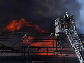 A firefighter tries to extinguish the flames at the historic Boersen stock exchange building which is on fire in central Copenhagen, Denmark on April 16, 2024.