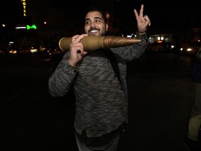 An Iranian demonstrator flashes a victory sign as he holds a model of a bullet during an anti-Israeli gathering at the Felestin (Palestine) Square in Tehran, Iran, early Sunday, April 14, 2024. Iran launched its first direct military attack against Israel on Saturday night.