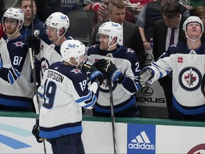 Winnipeg Jets center David Gustafsson (19) celebrates with the bench after scoring in the second period of an NHL hockey game against the Dallas Stars in Dallas, Thursday, April 11, 2024. (AP Photo/Tony Gutierrez)