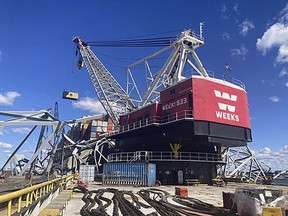 In this photo provided by the Key Bridge Response 2024 Unified Command, response crews begin removing shipping containers from the deck of the cargo ship Dali using a floating crane barge at the site of the Francis Scott Key Bridge, Sunday, April 7, 2024, in Baltimore.