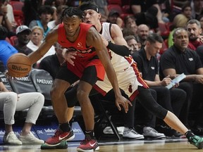 Raptors guard Immanuel Quickley (left) dribbles the ball as Heat guard Tyler Herro defends during first half NBA action in Miami, Friday, April 12, 2024.