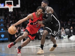 Toronto Raptors guard Immanuel Quickley (5) drives against Brooklyn Nets guard Dennis Schroder during the second half of an NBA basketball game, Wednesday, April 10, 2024, in New York.