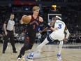 Toronto Raptors guard Gradey Dick works toward the basket as Minnesota Timberwolves forward Jaden McDaniels defends during the first half of an NBA basketball game, Wednesday, April 3, 2024, in Minneapolis.