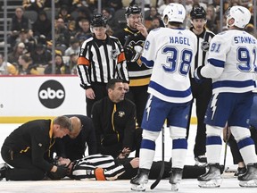 Medical staff tends to referee Steve Kozari after he and the Lightning's Haydn Fleury collided in the third period of an NHL game in Pittsburgh, Saturday, April 6, 2024.