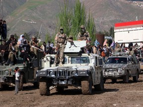 Taliban security personnel stand guard atop a Humevee vehicle during a game of 'Buzkashi' at a field in Fayzabad, Badakhshan province, on April 16, 2024.