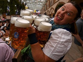 A waitress reacts as she carries beer mugs in a festival tent during the opening of the Oktoberfest 2023, Munich's annual beer festival, on September 16, 2023 in Munich, southern Germany.