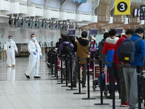 People line up and check in for an international flight at Pearson International Airport during the COVID-19 pandemic in Toronto on Wednesday, Oct. 14, 2020.