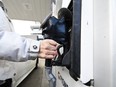 A woman gasses up at a gas station in Mississauga, Ont., Tuesday, Feb. 13, 2024.