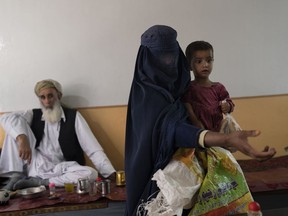 Ottawa has plans to ensure Canadian aid can finally flow to Afghanistan this year. But by the time its new system is fully up and running, the Taliban will have been in control of the country for about three years. A woman wearing a burqa begs while carrying her daughter inside a tea shop in Kabul, Afghanistan, Thursday, June 8, 2023.