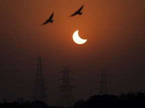 With Monday's solar eclipse expected to draw thousands to regions along the path of totality in Eastern Canada, major cellphone and internet providers say they're ready to handle a jolt in wireless traffic in those areas. Eagles fly past a partial solar eclipse in New Delhi, India, Tuesday, Oct. 25, 2022.