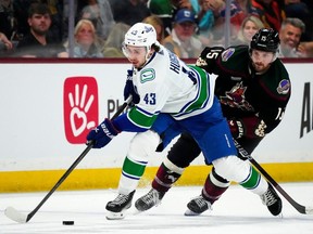 Vancouver Canucks defenseman Quinn Hughes skates with the puck against Arizona Coyotes centre Alex Kerfoot during the second period on April 3, 2024, in Tempe, Ariz.